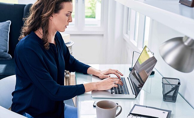 Eine Frau sitzt im Büro am Laptop