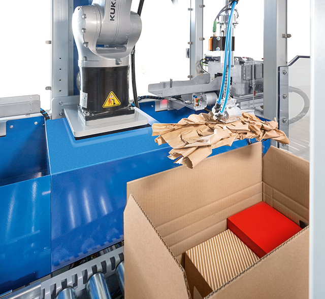
			A paper cushion is placed fully automatically in a box containing goods for shipment.